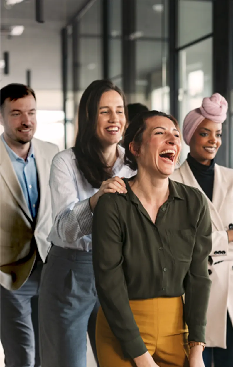 Professionals laughing together during a fun group activity, highlighting how The Thread Experience reveals unexpected common threads between strangers.